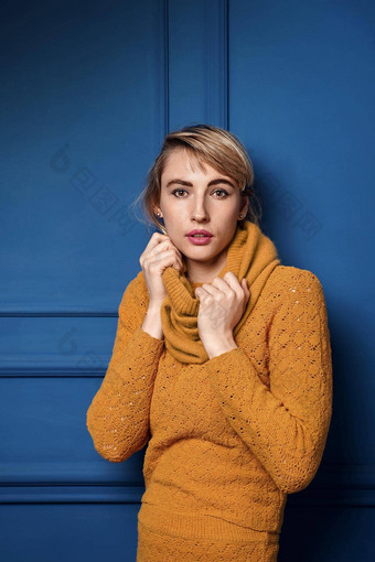 工作室肖像年轻的女人黄色的<strong>套衫</strong>蓝色的墙背景