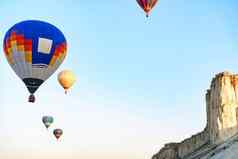 色彩斑斓的空气气球飞行清晰的天空巨大的白色山