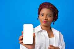 年轻的非洲式发型女人显示空白智能手机屏幕蓝色的背景