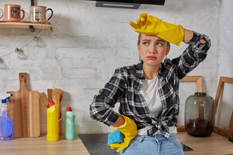 金发女郎女人保护手套破布清洁电炉子首页厨房女孩洗黑色的闪亮的表面厨房前