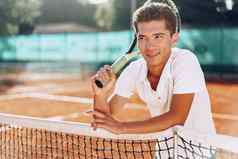 年轻的混合比赛男人。网球球员球拍站网球法院