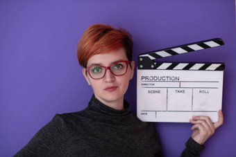 红色头发的人女人持有电影克拉珀紫色的背景
