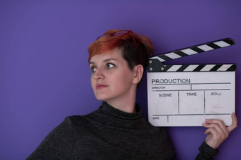 红色头发的人女人持有<strong>电影</strong>克拉珀紫色的背景