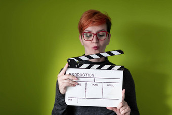 红色头发的人女人持有电影克拉珀绿色背景