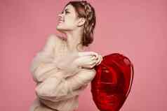 美丽的女人红色的心手气球粉红色的背景