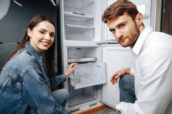 年轻的夫妇选择冰箱<strong>家庭设备</strong>商店