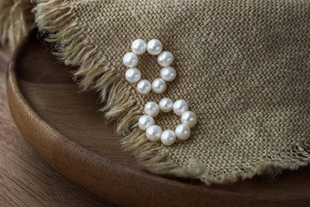 白色珍珠珠宝时尚摄影耳环白色珍珠时尚摄影耳环提出了棕色（的）麻布