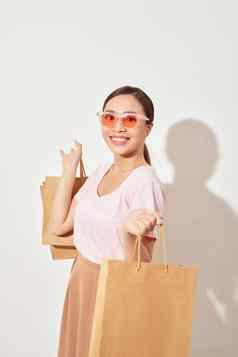 美丽的年轻的亚洲女人持有购物袋微笑好情绪快乐的购物假期购物中心