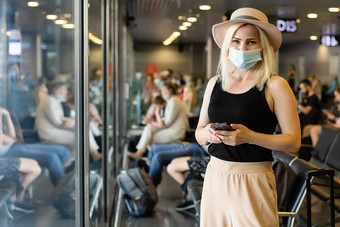 女人穿面具防止病毒行李国际机场保护冠状病毒