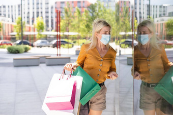 女人穿面具脸走购物购物中心购物袋医疗保健预防冠状病毒科维德流感