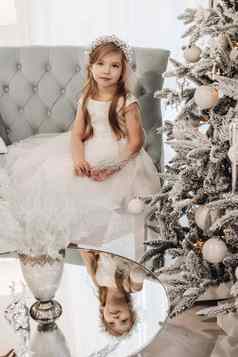 美丽的孩子不错的微笑坐在圣诞节树沙发首页