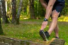 年轻的持久的运动运动员伸展运动森林在户外森林橡木树跑步者生活方式慢跑者适合人马拉松公园幸福夏天运行脚延伸