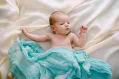 新生儿谎言米色毯子覆盖蓝色的围巾