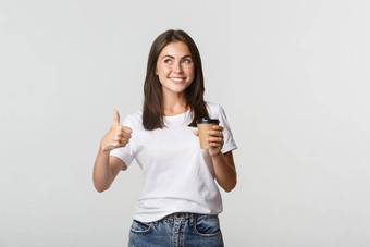 有吸引力的微笑浅黑肤色的女人女孩满意喝咖啡显示竖起大拇指推荐咖啡馆