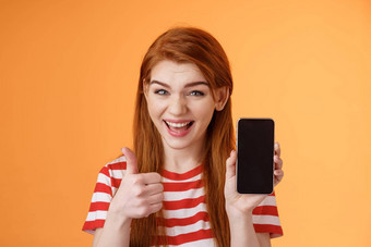 快乐的自信的红色头发的人女人<strong>推荐</strong>智能手机应用程序显示电话显示翘拇指批准<strong>标志</strong>微笑广泛的建议好在线购买移动广告