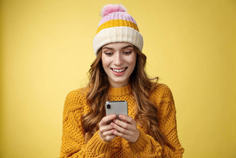 惊讶惊讶可爱的女孩收到好新闻阅读令人兴奋的消息持有智能手机扩大眼睛微笑移动电话显示玩太棒了手机游戏发短信发送图片冬天假期