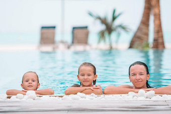 妈妈。孩子们享受夏天假期奢侈品游泳池