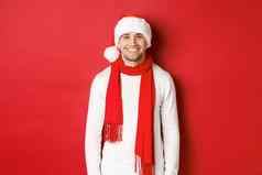 快乐高加索人的家伙庆祝圣诞节微笑穿圣诞老人他围巾白色毛衣享受一年假期站红色的背景