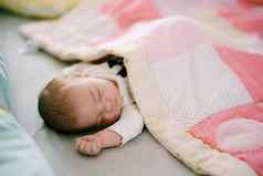 婴儿睡觉床上覆盖粉红色的拼接而成被子