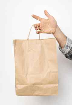 男人。手格子衬衫扭曲的袖手持有棕色（的）纸袋孤立的白色背景交付概念纸袋外卖食物交付携带