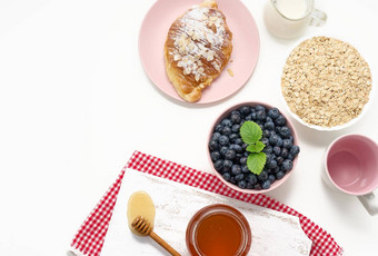 生燕麦片白色陶瓷板<strong>蓝莓</strong>蜂蜜白色表格早餐前视图