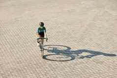 空中视图拍摄专业女骑自行车的人骑自行车服装保护齿轮骑自行车培训在户外温暖的阳光明媚的一天