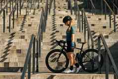 完整的长度拍摄专业女骑自行车的人骑自行车服装保护齿轮站步骤自行车培训骑城市中心