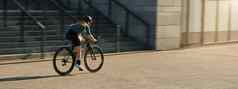 专业女骑自行车的人骑自行车服装保护齿轮骑自行车城市冲通过建筑培训在户外白天