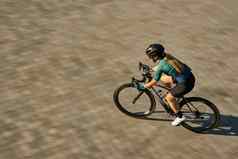高角视图拍摄专业女骑自行车的人骑自行车服装保护齿轮集中骑自行车培训在户外白天