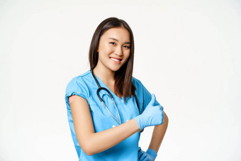 微笑亚洲女医生护士实习医生<strong>风云</strong>显示接种疫苗手流感科维德疫苗接种运动显示拇指白色<strong>背景</strong>