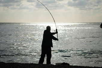 男人。爱好钓<strong>鱼</strong>海收紧钓<strong>鱼</strong>行卷<strong>鱼</strong>平静表面海特写镜头渔夫手扭卷钓<strong>鱼</strong>行杆钓<strong>鱼蓝色</strong>的海在户外