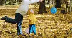 小孩子玩妈妈。充气气球秋天自然