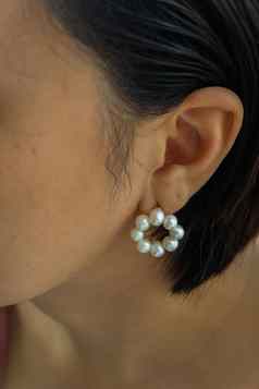 细节年轻的女人穿美丽的白色珍珠耳环