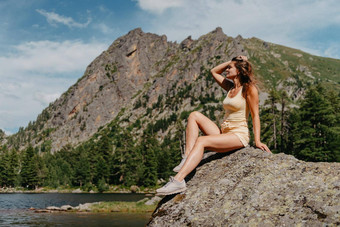 <strong>旅游</strong>女孩享受神奇的视图湖松柏科的森林神奇的视图坐着大石头海岸绿松石湖山徒步旅行自然公园可爱的女孩<strong>旅游</strong>坐着大石头湖水清晰的石头可见水