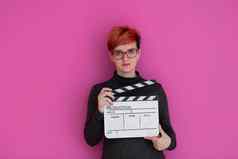 红色头发的人女人持有电影克拉珀粉红色的背景