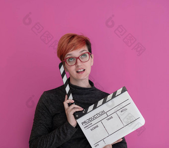 红色头发的人女人持有<strong>电影</strong>克拉珀粉红色的背景