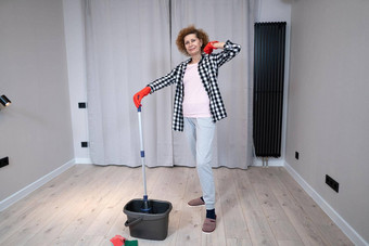 快乐的兴奋成熟的女人享受清洁房子跳舞洗地板上快乐上了年纪的女人享受清洁地板移动公寓做家务管家概念