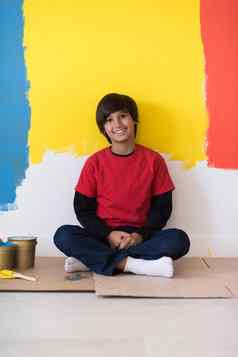 年轻的男孩画家休息绘画墙