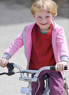 可爱的女孩开车bicyle阳光明媚的一天
