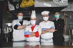 集团厨师站厨房餐厅穿保护医疗面具手套冠状病毒正常的概念