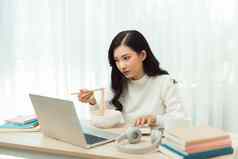年轻的亚洲女孩坐着桌子上工作加班享受放松时间女工作