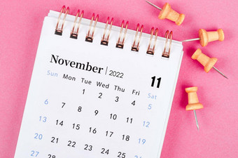 11月桌子上日历木销粉红色的背景