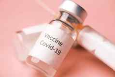 关闭冠状病毒疫苗注射器粉红色的背景