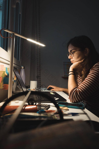 女孩工作移动PC首页学生研究首页自由职业者在线工作晚些时候晚上桌子上工作首页办公室