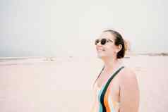 年轻的女人泳衣太阳镜微笑阳光明媚的一天海滩自由假期概念复制空间