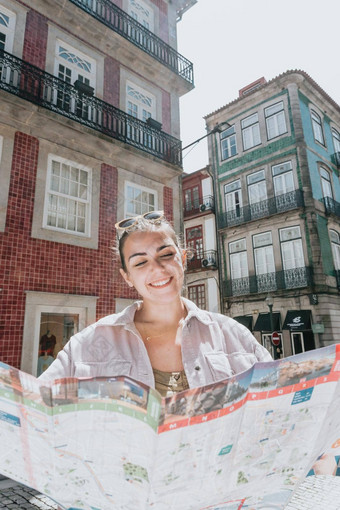 年轻的女人旅游地图中间街微笑思考计划夏天一天阳光明媚的港口地中海城市