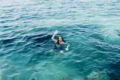 年轻的男人。浮动海洋假期西班牙水晶清晰的海耶和华见证人相机复制空间