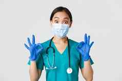 科维德冠状病毒疾病医疗保健工人概念兴奋深刻的印象亚洲医生护士医疗面具橡胶手套显示手势批准赞美不错的工作