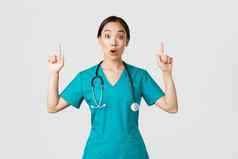 科维德医疗保健工人流感大流行概念惊讶激动亚洲女护士女人医生实习医生风云问题有趣的促销指出手指显示诊所广告