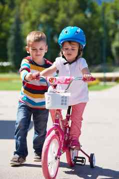 男孩女孩公园学习骑自行车